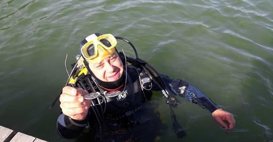 Taucher fischt Brille aus dem Fluss